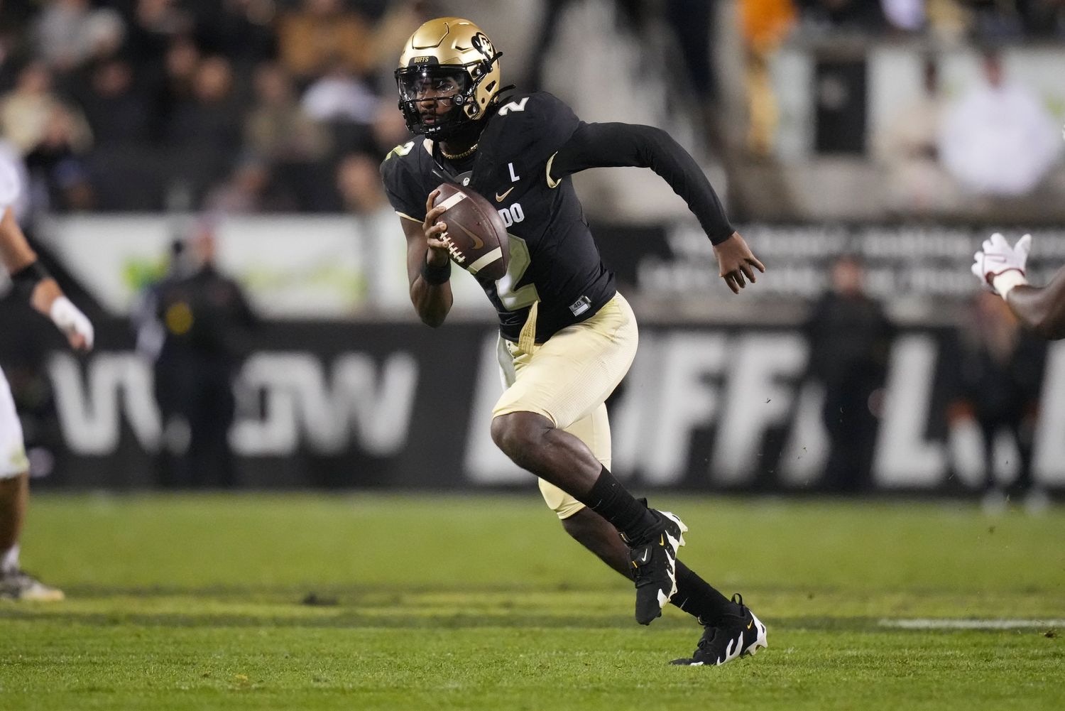 Colorado Buffaloes quarterback Shedeur Sanders scrambles with the football.